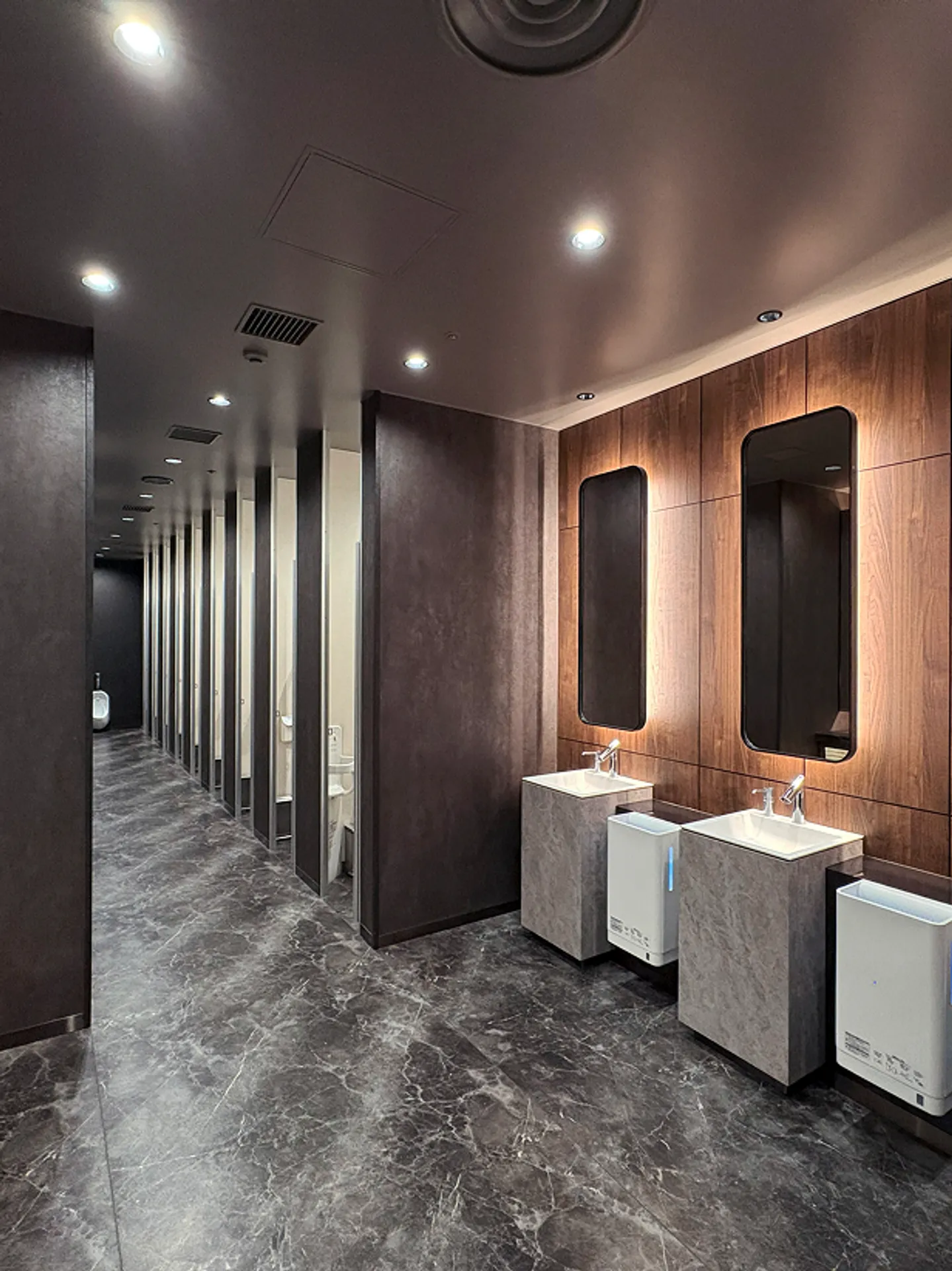 商業施設の洗面スペース施工事例｜木調パネルと間接照明を組み合わせた空間デザイン
